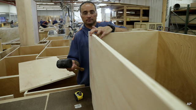 In a photo from Friday, July 8, 2016, inmate William Garrett works on a cabinet at the Habitat for Humanity Prison Build at the Ionia Correctional Facility in Ionia, Mich. Few states have been more aggressive in releasing inmates and diverting offenders than Michigan, where the prison system has long threatened the state's capacity to fund universities and other basics of government. But the $2 billion annual cost remains steep, exacerbated by a boomerang found here and across the country: the large number of inmates who wind up back behind bars again. Now Michigan leaders, frustrated that their downsizing efforts have hit a wall, are trying novel, more hands-on methods to ensure that prisoners leave with a job in hand. (AP Photo/Carlos Osorio)