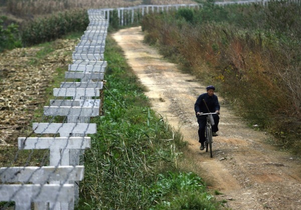 Dandong, Cina. La Cina a lungo alleata della Corea del Nord, ha deciso nel 2003 di costruire un muro lungo i suoi confini; il progetto ha avuto un'accelerazione in seguito agli esperimenti nucleari condotti dal governo di Pyongyang e alla fuga di numerosi profughi nord-coreani che chiedevano asilo politico in Cina: lasciare la Corea del Nord senza un permesso ufficiale è infatti considerato alto tradimento ed è un reato che viene punito con la pena capitale.