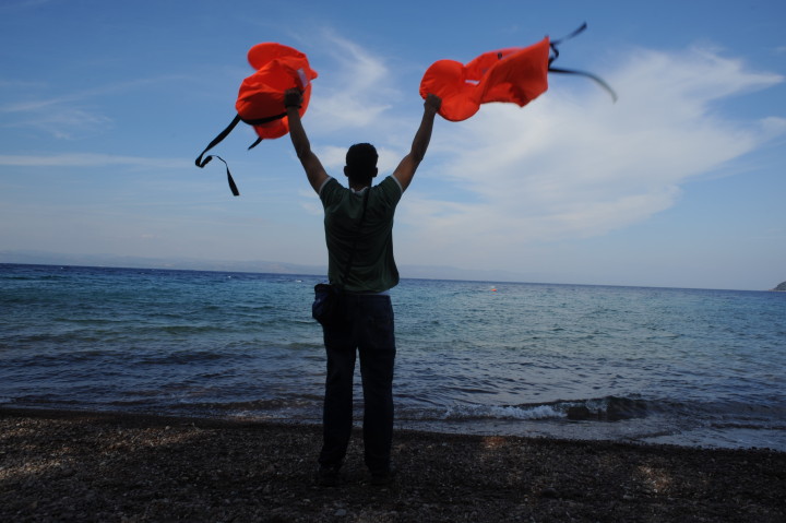 October 5, 2015-Lesvos, North-east Aegean sea, Greece: Man moves his hands holding two life-jackets, in order to attrack the refugees' boats. Refugees arrive to the coast of the Greek island Lesvos, into small plastic and cheap boats from the Turkish land. (Maro Kouri)