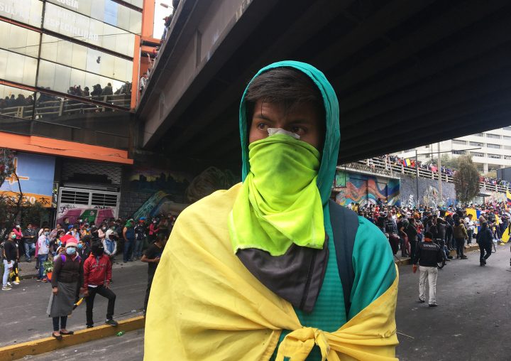 Durante las movilizaciones de Octubre en Quito, un joven observa.