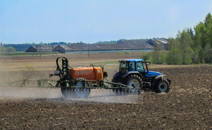Tractor rociando pesticidas en el campo.