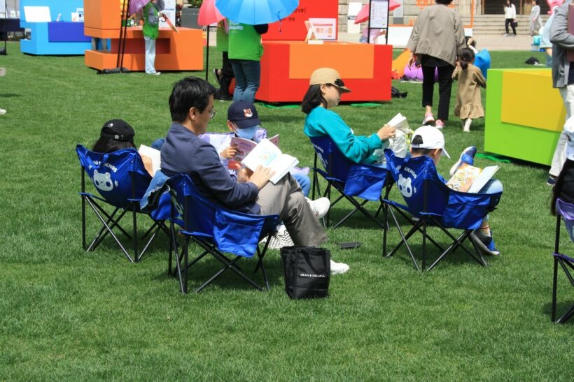 Entire families sit to enjoy their books.