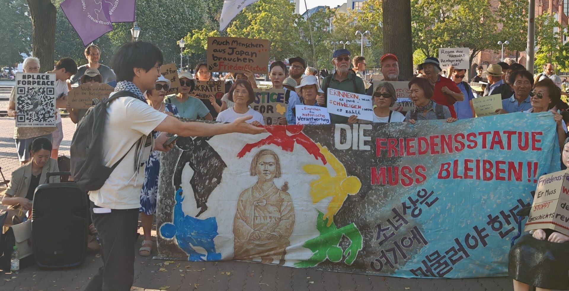 Der Korea Verband leitet rechtliche Schritte für den Erhalt der Friedensstatue Ari ein! Was zu befürchten war: die Friedensstatue ARI soll trotz aller Gegenproteste abgebaut werden. Wir berichteten mehfach dazu. [1] [2] Von Peter Vlatten In Berlin darf in Zeiten der „Kriegstüchtigkeit“ an die schlimmen Hässlichkeiten des Krieges wohl nicht konkret erinnert werden. Vor allem wenn es um die systematische sexualisierte Gewalt gegen Frauen geht, die von der eigenen Kriegspartei oder einer verbündeten Nation begangen werden. Besonders der Berliner Regierende Bürgermeister Kai Wegner, der sich immer mehr als unduldsamer Fan der Kriegspolitik eines Netanyahus outet und sich für einen „kompromisslosen“ Ukrainekrieg bis zum letzten Ukrainer auszusprechen scheint, kennt da kein Pardon. Die eigene weiße Weste oder die einer verbündeten Nation dürfen um keinen Preis -schon gar nicht um der Wahrheit willen – beschmutzt werden. Die eigenen Verantwortlichen und Täter sollen nicht benannt werden. Kriegsverbrechen begehen immer nur die anderen, nie die eigene Kriegspartei. Die muss geschützt werden, nicht die Opfer und Frauen. Kai Wegner und die ihn unterstützenden Politiker demonstrieren immer unverhohlener ihre Macht, um ihre Haltung durchzusetzen. Dagegen im Einzelfall, vor allem auch angesichts der dubiosen Umstände, mit der die Statue beseitigt werden soll, per Gericht vorzugehen, ist einen Versuch wert. Generell bedarf es aber einer deutlich erstarkenden Friedensbewegung in ganz Deutschland, damit die Macht der Kriegsertüchtiger wieder in ihre Schranken verwiesen werden kann! Der Koreaverband e.V. leitet nun rechtliche Schritte ein. Hier die öffentliche Erklärung dazu [3] „Am 24. September fand ein Gespräch zwischen dem Korea Verband und der Bezirksbürgermeisterin von Berlin-Mitte, Stefanie Remlinger, statt. Ziel des Treffens war es, gemeinsam eine Lösung für den Erhalt der Friedensstatue Ari in Berlin-Moabit zu finden. Trotz unserer Bemühungen wurde uns vorgeworfen, mangelnde Kompromissbereitschaft gezeigt zu haben, da wir dem Druck des Bezirksamts standhielten und die Friedensstatue Ari ohne konkrete Informationen nicht auf ein privates Grundstück verlegen wollten. Der Korea Verband bekräftigte mehrfach seine Bereitschaft, an einer Kompromisslösung zu arbeiten. Um einen Rechtsstreit zu vermeiden, unterbreitete der Korea Verband nach dem Treffen am 26. September 2024 nochmals ein Vergleichsangebot an das Bezirksamt, das hier eingesehen werden kann: Vergleichsvorschlag. Zuvor hatte der Korea Verband bereits am 21. August einen Antrag auf Verlängerung der Sondernutzung für die Friedensstatue eingereicht. Weder zu unserem Vergleichsangebot noch zu unserem Antrag haben wir jemals eine Rückmeldung erhalten. Ablehnungsbescheid zur Verlängerung der Sondernutzung der Friedensstatue und Anordnung zur Beseitigung Am 30. September hat das Bezirksamt Berlin Mitte den Antrag auf Verlängerung der Sondernutzung abgelehnt und die Beseitigung der Friedensstatue bis zum 31. Oktober 2024 angeordnet. In dem Bescheid wird ausgeführt, dass der Antrag vom 21. August 2024 abgelehnt wurde und die Statue bis zum 31. Oktober 2024 vollständig aus dem öffentlichen Straßenland entfernt werden muss. Zudem wird die sofortige Vollziehbarkeit dieser Anordnung angeordnet. Kommt der Korea Verband der Forderung bis zur genannten Frist nicht nach, droht ein Zwangsgeld in Höhe von 3.000 €. Zusätzlich wurde eine Gebühr von 330,84 € für den Bescheid festgelegt. Der Ablehnungsbescheid kann hier eingesehen werden: Ablehnungsbescheid. Der Korea Verband bedauert sowohl die Entscheidung als auch den unnachgiebigen Ton des Bescheids. Darin wurde uns unter anderem unlautere Motive vorgeworfen. So heißt es: „In den vergangenen Jahren hat Ihre Mandantin mehrere Demonstrationen zugunsten des Verbleibs der Friedensstatue am aktuellen Standort durchgeführt und erfolgreiche Lobbyarbeit zugunsten des Verbleibs der Statue an dem bisherigen Standort betrieben.” (Siehe Ablehnungsbescheid vom 30.09., S. 4). Eilantrag gegen Ablehnungsbescheid und Beseitigungsanordnung Gegen den Bescheid des Bezirksamts hat der Korea Verband am 10. Oktober 2024 Widerspruch eingelegt und bis zum 14. Oktober 2024 um Entscheidung gebeten. Da nach Ablauf dieser Frist das Bezirksamt Mitte erneut nicht reagiert hatte, sah sich der Korea Verband gezwungen, rechtliche Schritte einzuleiten und gerichtlichen Eilrechtsschutz in Anspruch zu nehmen. Der Eilantrag kann hier eingesehen werden: Eilantrag. Dies zielt darauf ab, die Beseitigung der Friedensstatue Ari zu verhindern und den Erhalt dieses wichtigen Symbols für Frieden, Menschenrechte und den Kampf gegen sexualisierte Gewalt in Kriegen zu sichern. Der Korea Verband wird alle rechtlichen Mittel ausschöpfen, um Ari zu schützen und setzt sich dafür ein, dass die Statue an ihrem bedeutenden Standort in Moabit bleibt, wo sie seit vier Jahren Teil der Gemeinschaft ist und durch das Museum der Trostfrauen (MuT) wertvolle Bildungsarbeit leistet.„ Titelfoto Peter Vlatten [1] https://gewerkschaftliche-linke-berlin.de/sagt-nein-zu-jeglicher-sexualisierter-gewalt-in-kriegen/ [2] https://gewerkschaftliche-linke-berlin.de/?s=Friedenstatue+Ari [3] https://koreaverband.de/blog/2024/10/23/der-korea-verband-leitet-rechtliche-schritte-fuer-den-erhalt-der-friedensstatue-ari-ein/