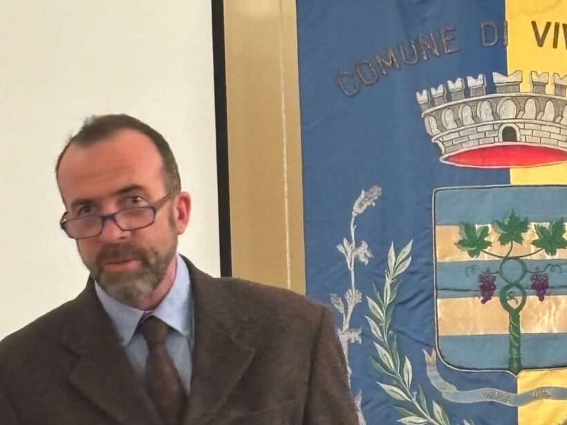 Ettore Macchieraldo mentre fa un discorso co sullo sfondo il gonfalone del Comune di Viverone