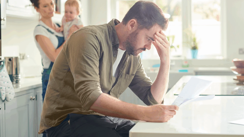 Un signore che guarda una bolletta da pagare