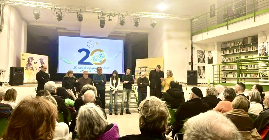 Un gruppo di relatori sul palco dello Spazio Comunale Piazza Forcella, di fronte a un numeroso pubblico. Sullo sfondo, lo schermo con il logo ufficiale dell’evento. L’incontro rientra nella programmazione del XVII Festival del Cinema dei Diritti Umani, con la presentazione del docufilm Sniper Alley – To My Brother.