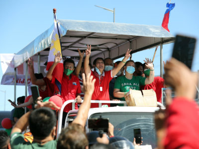 Former Senator Ferdinand Marcos Jr. and presidential daughter Davao City Mayor Sara Z. Duterte waving to the crowd from their float during a grand caravan along Commonwealth Avenue in Quezon City.