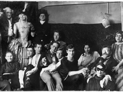 Photograph of a costume party held at the Institute for Sexual Research (Institut für Sexualwissenschaft) on an unknown date. Magnus Hirschfeld is in glasses, right, holding hands with his partner, the archivist Karl Giese — Source (Credit: Magnus-Hirschfeld-Gesellschaft e.V., Berlin. Not public domain)