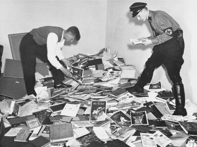 Photograph of a student and a member of the Nazi SA examining materials from the Institute for Sexual Research. Many books were burnt at Berlin’s Opera Square, while particularly valuable manuscripts were sold abroad — Source.