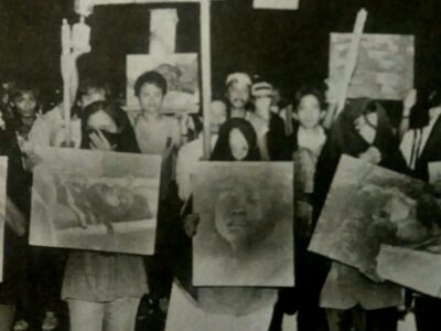 1986 rally against the Marcos Dictatorship in which protesters hold up images of Escalante Massacre victims. Wikimedia Commons.