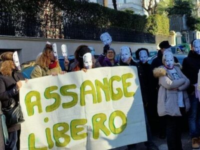 Protesters wearing Julian Assange masks in front of the Australian Embassy in Rome (white building) during a sit-in held on the occasion of Carnival Day, Feb. 12, 2023