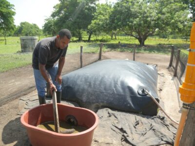 Elkin Palacin feeds the biodigester he uses to produce biogas daily with manure from his cows on his farm El Triunfo in the municipality of Ponedera, northern Colombia.