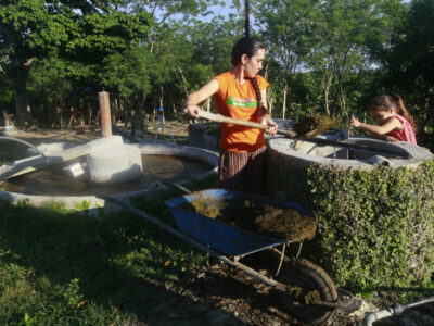 Artist and farmer Chavely Casimiro and her daughter Leah Amanda Díaz feed one of the biodigesters at Finca del Medio in central Cuba. They produce about seven metres of biogas per day, enough energy for cooking, baking and dehydrating food.