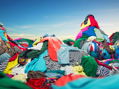 Big heap of colorful clothes on sky background