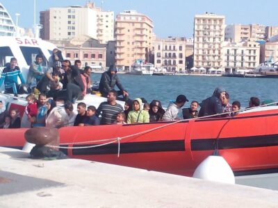 إنزال مهاجرين في ميناء تراباني (صقلية) من قارب خفر السواحل الإيطالي في عام 2014