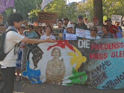 Der Korea Verband leitet rechtliche Schritte für den Erhalt der Friedensstatue Ari ein! Was zu befürchten war: die Friedensstatue ARI soll trotz aller Gegenproteste abgebaut werden. Wir berichteten mehfach dazu. [1] [2] Von Peter Vlatten In Berlin darf in Zeiten der „Kriegstüchtigkeit“ an die schlimmen Hässlichkeiten des Krieges wohl nicht konkret erinnert werden. Vor allem wenn es um die systematische sexualisierte Gewalt gegen Frauen geht, die von der eigenen Kriegspartei oder einer verbündeten Nation begangen werden. Besonders der Berliner Regierende Bürgermeister Kai Wegner, der sich immer mehr als unduldsamer Fan der Kriegspolitik eines Netanyahus outet und sich für einen „kompromisslosen“ Ukrainekrieg bis zum letzten Ukrainer auszusprechen scheint, kennt da kein Pardon. Die eigene weiße Weste oder die einer verbündeten Nation dürfen um keinen Preis -schon gar nicht um der Wahrheit willen – beschmutzt werden. Die eigenen Verantwortlichen und Täter sollen nicht benannt werden. Kriegsverbrechen begehen immer nur die anderen, nie die eigene Kriegspartei. Die muss geschützt werden, nicht die Opfer und Frauen. Kai Wegner und die ihn unterstützenden Politiker demonstrieren immer unverhohlener ihre Macht, um ihre Haltung durchzusetzen. Dagegen im Einzelfall, vor allem auch angesichts der dubiosen Umstände, mit der die Statue beseitigt werden soll, per Gericht vorzugehen, ist einen Versuch wert. Generell bedarf es aber einer deutlich erstarkenden Friedensbewegung in ganz Deutschland, damit die Macht der Kriegsertüchtiger wieder in ihre Schranken verwiesen werden kann! Der Koreaverband e.V. leitet nun rechtliche Schritte ein. Hier die öffentliche Erklärung dazu [3] „Am 24. September fand ein Gespräch zwischen dem Korea Verband und der Bezirksbürgermeisterin von Berlin-Mitte, Stefanie Remlinger, statt. Ziel des Treffens war es, gemeinsam eine Lösung für den Erhalt der Friedensstatue Ari in Berlin-Moabit zu finden. Trotz unserer Bemühungen wurde uns vorgeworfen, mangelnde Kompromissbereitschaft gezeigt zu haben, da wir dem Druck des Bezirksamts standhielten und die Friedensstatue Ari ohne konkrete Informationen nicht auf ein privates Grundstück verlegen wollten. Der Korea Verband bekräftigte mehrfach seine Bereitschaft, an einer Kompromisslösung zu arbeiten. Um einen Rechtsstreit zu vermeiden, unterbreitete der Korea Verband nach dem Treffen am 26. September 2024 nochmals ein Vergleichsangebot an das Bezirksamt, das hier eingesehen werden kann: Vergleichsvorschlag. Zuvor hatte der Korea Verband bereits am 21. August einen Antrag auf Verlängerung der Sondernutzung für die Friedensstatue eingereicht. Weder zu unserem Vergleichsangebot noch zu unserem Antrag haben wir jemals eine Rückmeldung erhalten. Ablehnungsbescheid zur Verlängerung der Sondernutzung der Friedensstatue und Anordnung zur Beseitigung Am 30. September hat das Bezirksamt Berlin Mitte den Antrag auf Verlängerung der Sondernutzung abgelehnt und die Beseitigung der Friedensstatue bis zum 31. Oktober 2024 angeordnet. In dem Bescheid wird ausgeführt, dass der Antrag vom 21. August 2024 abgelehnt wurde und die Statue bis zum 31. Oktober 2024 vollständig aus dem öffentlichen Straßenland entfernt werden muss. Zudem wird die sofortige Vollziehbarkeit dieser Anordnung angeordnet. Kommt der Korea Verband der Forderung bis zur genannten Frist nicht nach, droht ein Zwangsgeld in Höhe von 3.000 €. Zusätzlich wurde eine Gebühr von 330,84 € für den Bescheid festgelegt. Der Ablehnungsbescheid kann hier eingesehen werden: Ablehnungsbescheid. Der Korea Verband bedauert sowohl die Entscheidung als auch den unnachgiebigen Ton des Bescheids. Darin wurde uns unter anderem unlautere Motive vorgeworfen. So heißt es: „In den vergangenen Jahren hat Ihre Mandantin mehrere Demonstrationen zugunsten des Verbleibs der Friedensstatue am aktuellen Standort durchgeführt und erfolgreiche Lobbyarbeit zugunsten des Verbleibs der Statue an dem bisherigen Standort betrieben.” (Siehe Ablehnungsbescheid vom 30.09., S. 4). Eilantrag gegen Ablehnungsbescheid und Beseitigungsanordnung Gegen den Bescheid des Bezirksamts hat der Korea Verband am 10. Oktober 2024 Widerspruch eingelegt und bis zum 14. Oktober 2024 um Entscheidung gebeten. Da nach Ablauf dieser Frist das Bezirksamt Mitte erneut nicht reagiert hatte, sah sich der Korea Verband gezwungen, rechtliche Schritte einzuleiten und gerichtlichen Eilrechtsschutz in Anspruch zu nehmen. Der Eilantrag kann hier eingesehen werden: Eilantrag. Dies zielt darauf ab, die Beseitigung der Friedensstatue Ari zu verhindern und den Erhalt dieses wichtigen Symbols für Frieden, Menschenrechte und den Kampf gegen sexualisierte Gewalt in Kriegen zu sichern. Der Korea Verband wird alle rechtlichen Mittel ausschöpfen, um Ari zu schützen und setzt sich dafür ein, dass die Statue an ihrem bedeutenden Standort in Moabit bleibt, wo sie seit vier Jahren Teil der Gemeinschaft ist und durch das Museum der Trostfrauen (MuT) wertvolle Bildungsarbeit leistet.„ Titelfoto Peter Vlatten [1] https://gewerkschaftliche-linke-berlin.de/sagt-nein-zu-jeglicher-sexualisierter-gewalt-in-kriegen/ [2] https://gewerkschaftliche-linke-berlin.de/?s=Friedenstatue+Ari [3] https://koreaverband.de/blog/2024/10/23/der-korea-verband-leitet-rechtliche-schritte-fuer-den-erhalt-der-friedensstatue-ari-ein/