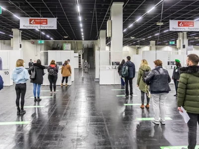 COVID-19-Impfzentrum in Halle 4 der Kölnmesse, Köln. Testlauf. Darsteller durchlaufen die verschiedenen Stationen. (Foto: © Raimond Spekking via Wikimedia Commons; CC-BY-SA 4.0 cropped)