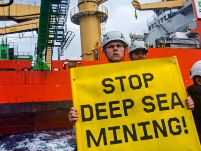 Greenpeace International activists attach a flag reading "Stop Deep Sea Mining'' to the cable holding the prototype robot, Patania II, to disturb a deep-sea mining impact test by the company Global Sea Mineral Resources.