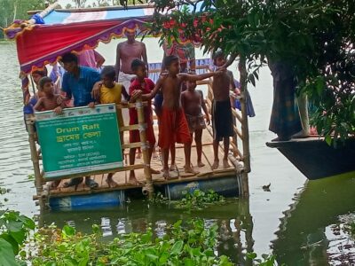 Members of a flood-affected family  riding on a raft made of plastic drums. The photo was taken from Chinir Patol Jola Para in Saghata, Gaibandha.