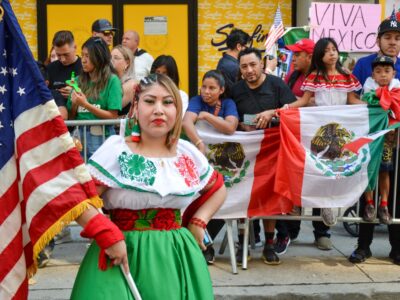 A closeup shot of a female holding the flag of the USA during the Mexican Independence Day Parade