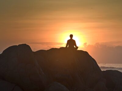 A man meditating on the beach at Vizag.